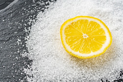 un morceau de citron sur de l’acide citrique