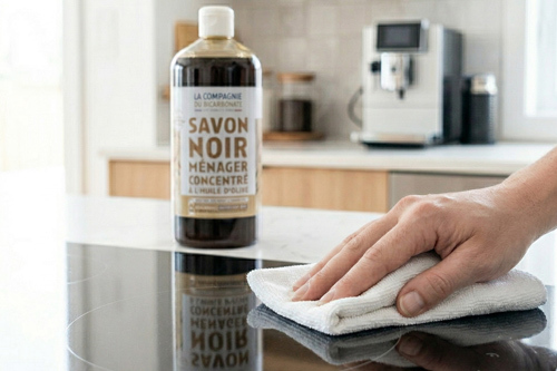 Nettoyage d'une plaque de cuisson grasse avec du savon noir liquide.