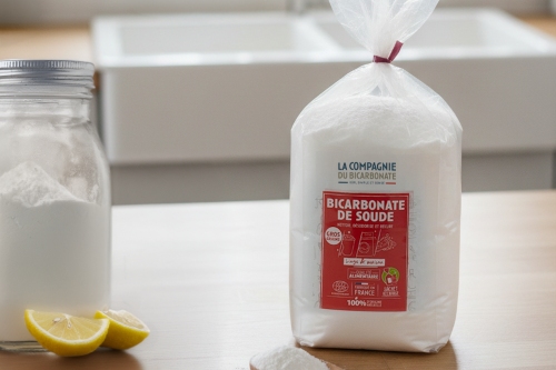 Pot de bicarbonate avec un sachet de bicarbonate de soude à côté.