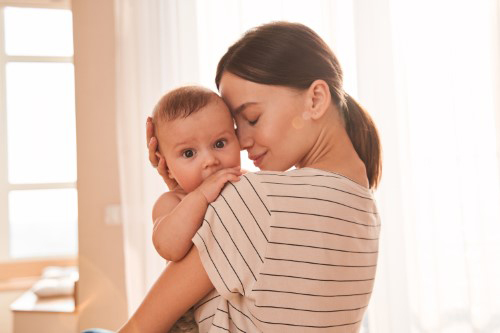 une maman enlaçant son bébé