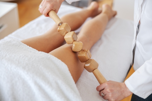 massage avec un rouleau masseur en bois
