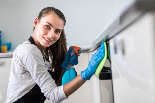 Femme qui nettoie son lave-vaisselle à l’aide de gants