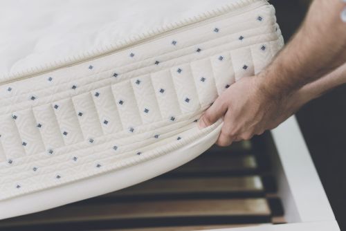 Main qui soulève un matelas